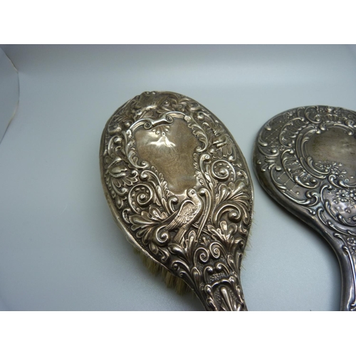 853 - Two silver backed brushes and a silver backed mirror