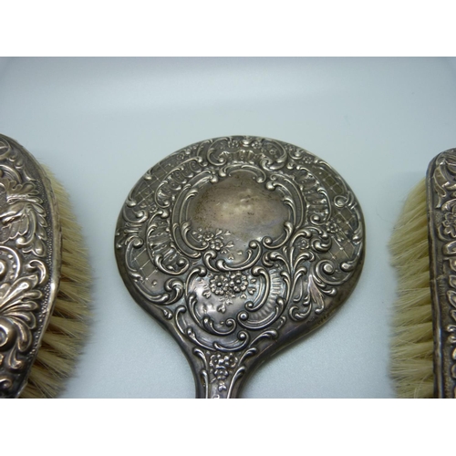 853 - Two silver backed brushes and a silver backed mirror