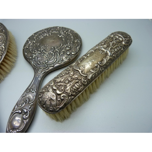 853 - Two silver backed brushes and a silver backed mirror