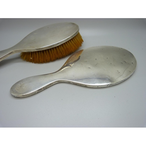 868 - A three piece silver vanity set, hand mirror and two brushes