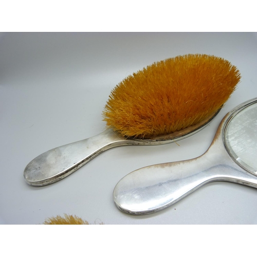 868 - A three piece silver vanity set, hand mirror and two brushes