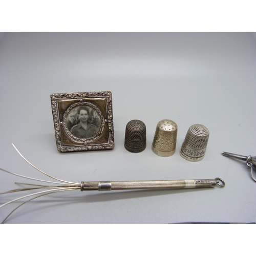 894 - Silver and white metal items: thimbles, a pencil, a frame, whistle, swizzle stick, etc.