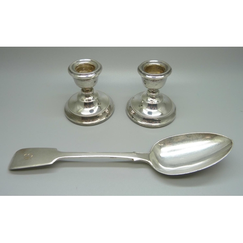 926 - A silver basting spoon, 79g and a pair of silver candlesticks