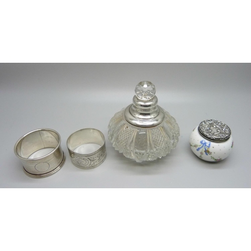 927 - Two silver napkin rings, 52g, silver topped scent bottle and a silver topped pot