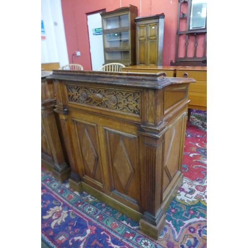 103 - A pair of Victorian Gothic Revival oak clerks desks, the gilt tooled red leather tops inset with Lat... 