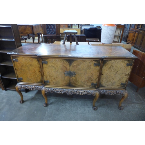 123 - An early 20th Century Queen Anne style carved burr walnut breakfront sideboard, retailed by Harrods,... 