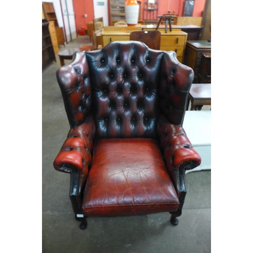 177 - A red leather Chesterfield wingback armchair