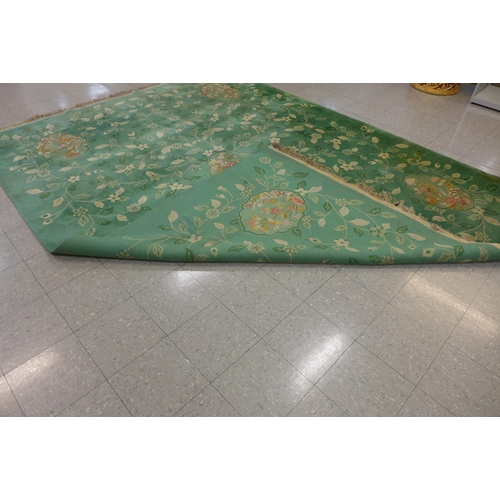 210 - A large Chinese green ground rug, 355 x 275cms