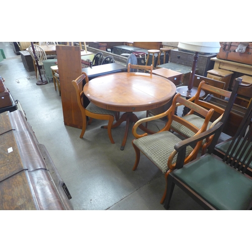 238 - A yew wood circular extending dining table and four chairs