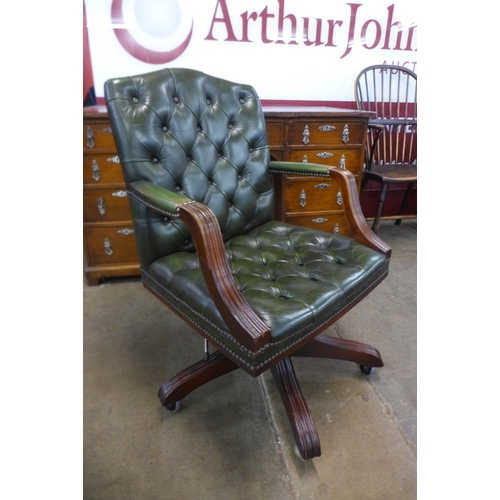 94 - A mahogany and green buttoned leather revolving desk chair