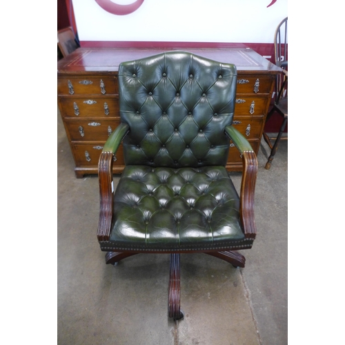 94 - A mahogany and green buttoned leather revolving desk chair