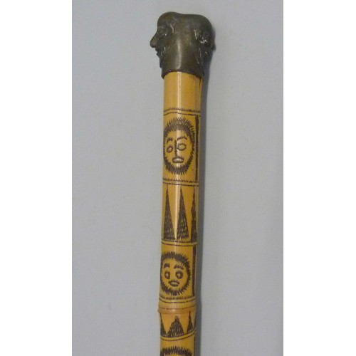 819 - A bamboo walking cane decorated with carved bearded heads