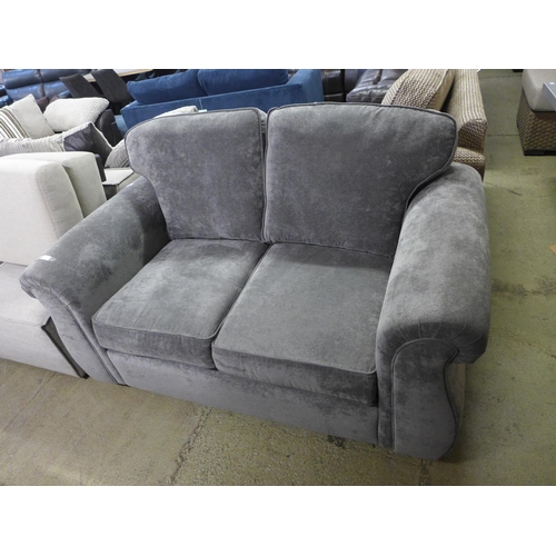 1997 - A grey upholstered two seater sofa - damaged leg