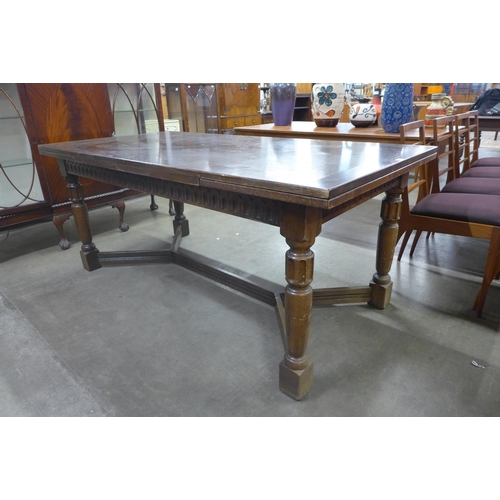 91 - A 17th Century style carved oak extending refectory table, 76cms h, 183cms l, 92cms w