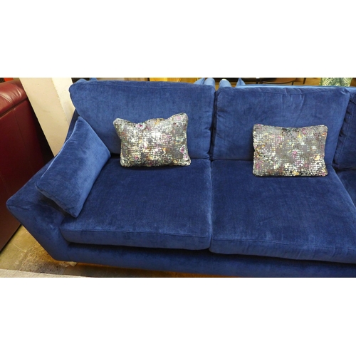 1354 - A blue velvet L shaped sofa with three contrasting scatter cushions