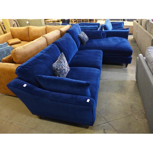 1437 - A blue velvet L shaped sofa with contrasting scatter cushions