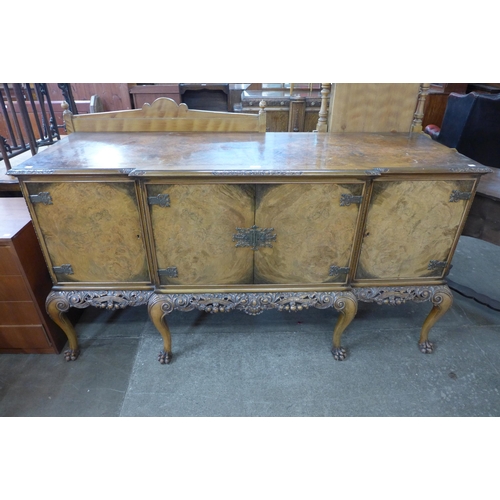 108 - An early 20th Century Queen Anne style carved burr walnut breakfront sideboard, retailed by Harrods,... 