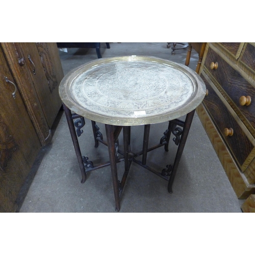 112 - A Chinese circular brass topped folding occasional table