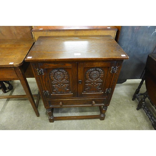 129 - A small Old Charm carved oak cupboard