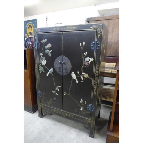 154 - A Chinese black chinoiserie two door cupboard