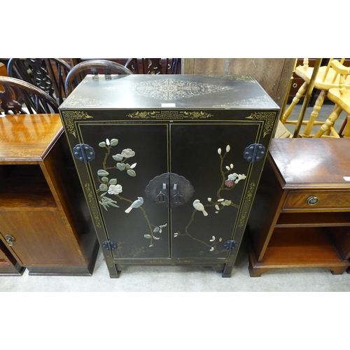 154 - A Chinese black chinoiserie two door cupboard