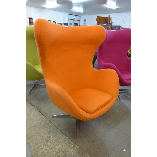 21 - An Arne Jacobsen style chrome and  orange fabric revolving egg chair