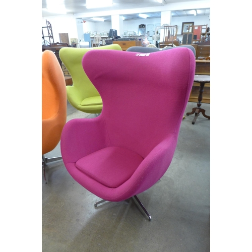 22 - An Arne Jacobsen style chrome and pink fabric revolving egg chair