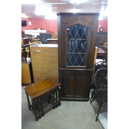 224 - An oak gateleg table and four chairs, a corner cabinet and a nest of tables