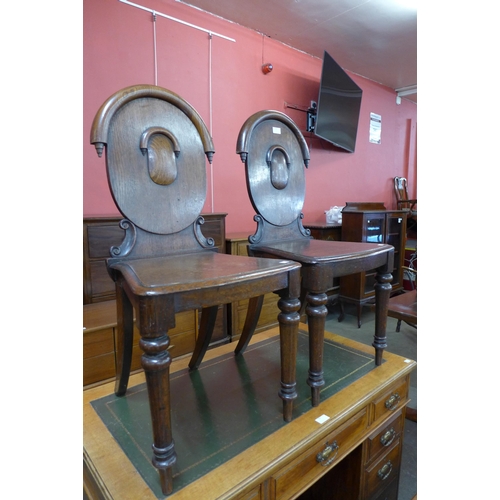 66 - A pair of Victorian oak hall chairs