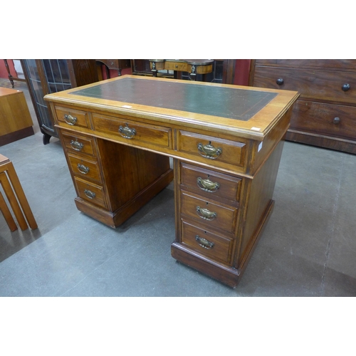 79 - A Victorian walnut and green leather topped pedestal desk