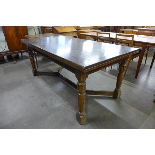 91 - A 17th Century style carved oak extending refectory table, 76cms h, 183cms l, 92cms w