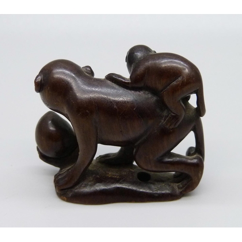 1037 - A carved rosewood netsuke of two monkeys, signed on the base