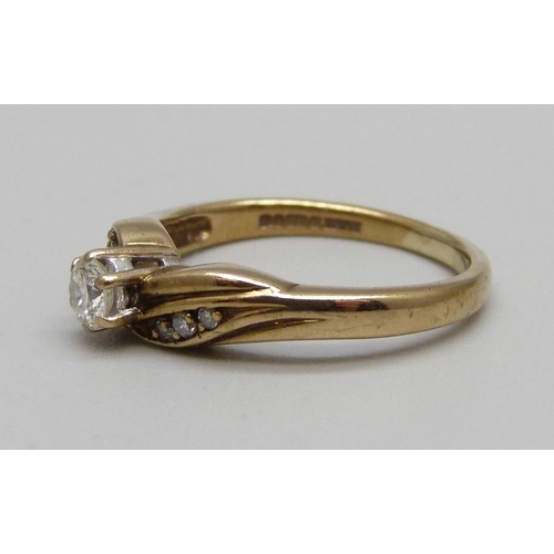 1051 - A 9ct gold and diamond ring with diamond shoulders, 2.7g, M