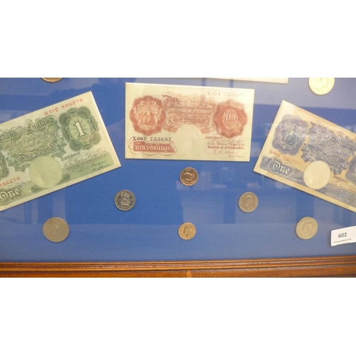 602 - A framed Five Pounds white bank note, two £1 notes, ten shillings note and other coins