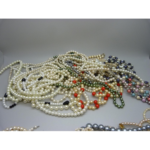 861 - Five strings of faux pearls with silver clasps, two pairs of earrings and a bag of faux pearls