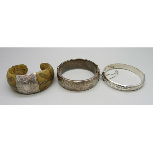 937 - Two silver bangles, 41g and a white metal mounted bone bracelet