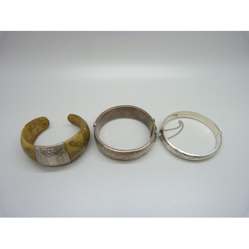 937 - Two silver bangles, 41g and a white metal mounted bone bracelet