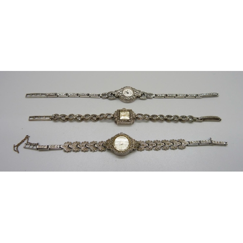 943 - Three lady's silver and marcasite wristwatches, one unmarked but tests as silver, winder missing on ... 