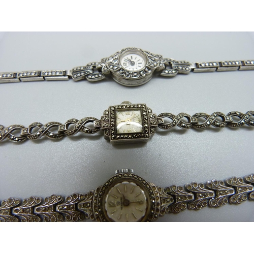 943 - Three lady's silver and marcasite wristwatches, one unmarked but tests as silver, winder missing on ... 