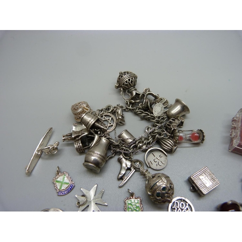 985 - A white metal charm bracelet and loose charms including silver, 125g