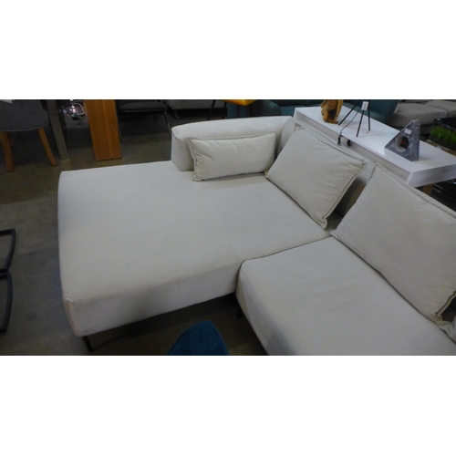 1308 - An ivory velvet corner sofa on steel legs