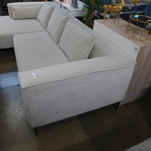 1308 - An ivory velvet corner sofa on steel legs