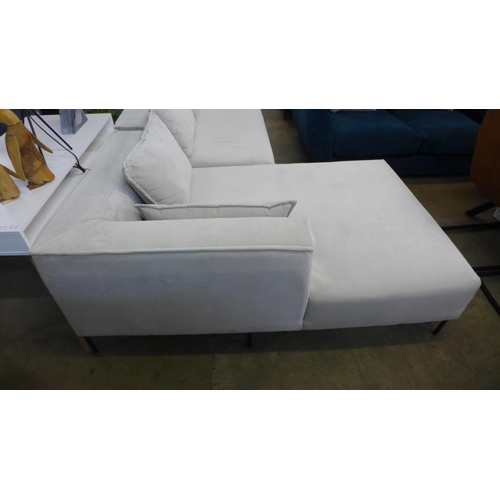 1308 - An ivory velvet corner sofa on steel legs