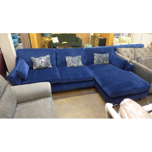 1307 - A blue velvet L shaped sofa with three contrasting scatter cushions