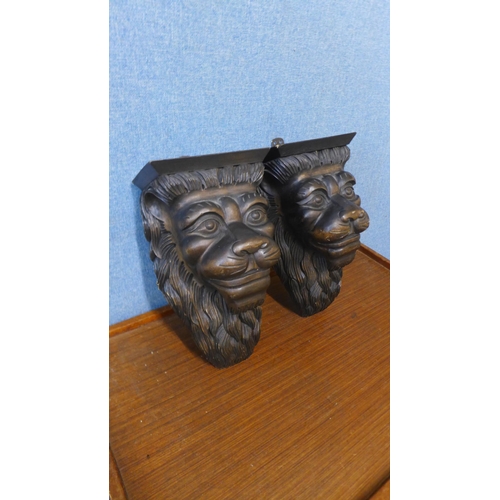 358 - A pair of carved wood lion's face wall brackets