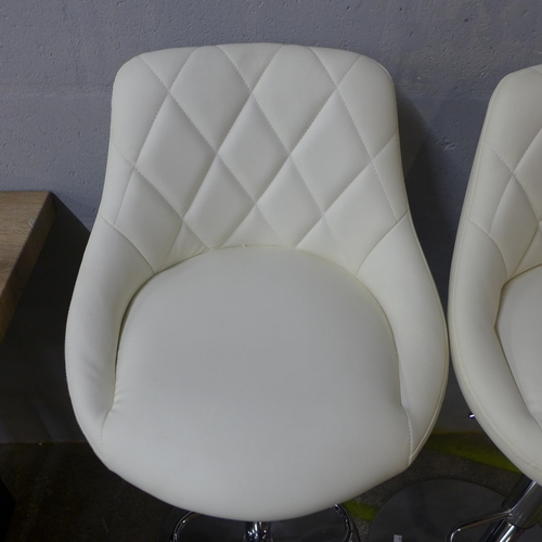 1502 - A pair of Aldin cream upholstered diamond stitching gas lift bar stools