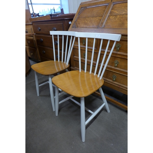 121 - A pair of Danish FDB Mobler painted beech kitchen chairs, designed by Poul Volther