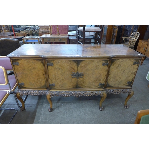 170 - An early 20th Century Queen Anne style carved burr walnut breakfront sideboard, retailed by Harrods,... 