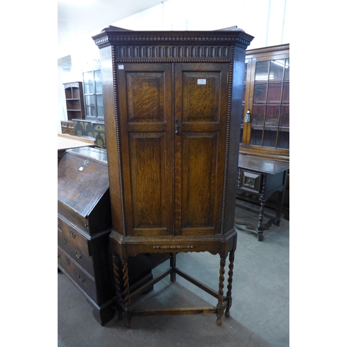 187 - An early 20th Century oak barleytwist freestanding corner cupboard