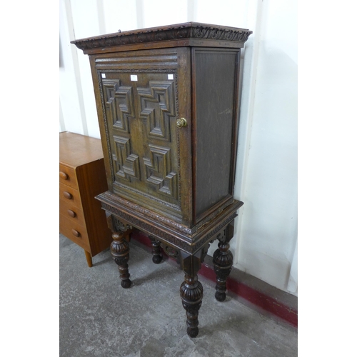 228 - An Elizabethan Revival carved oak geometric moulded cupboard on stand